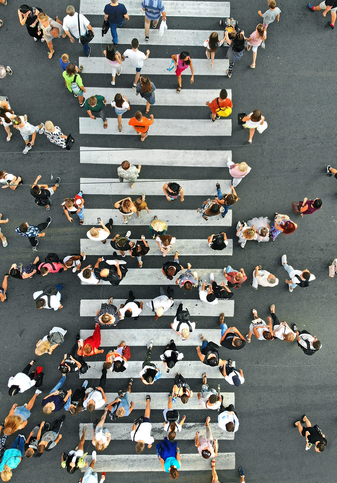 Aerial. People crowd on pedestrian crosswalk. Top view background.